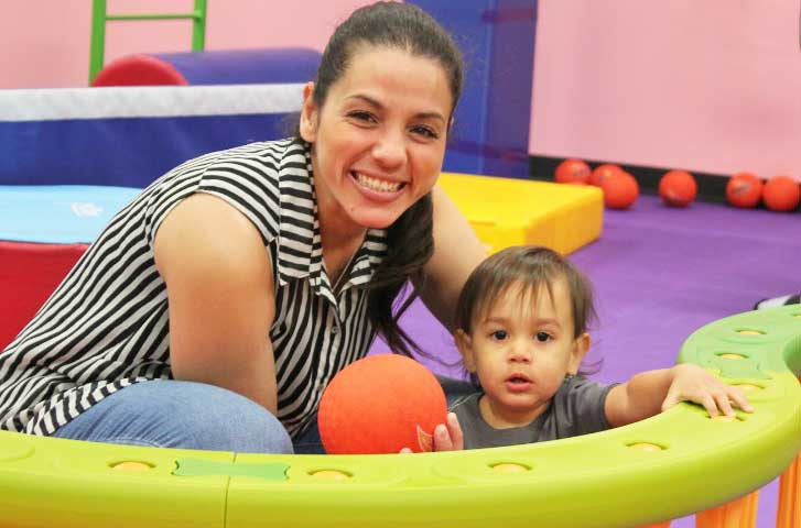 This mom and child play with a ball at Romp n' Roll Pittsburgh East's toddler gym in Pittsburgh.