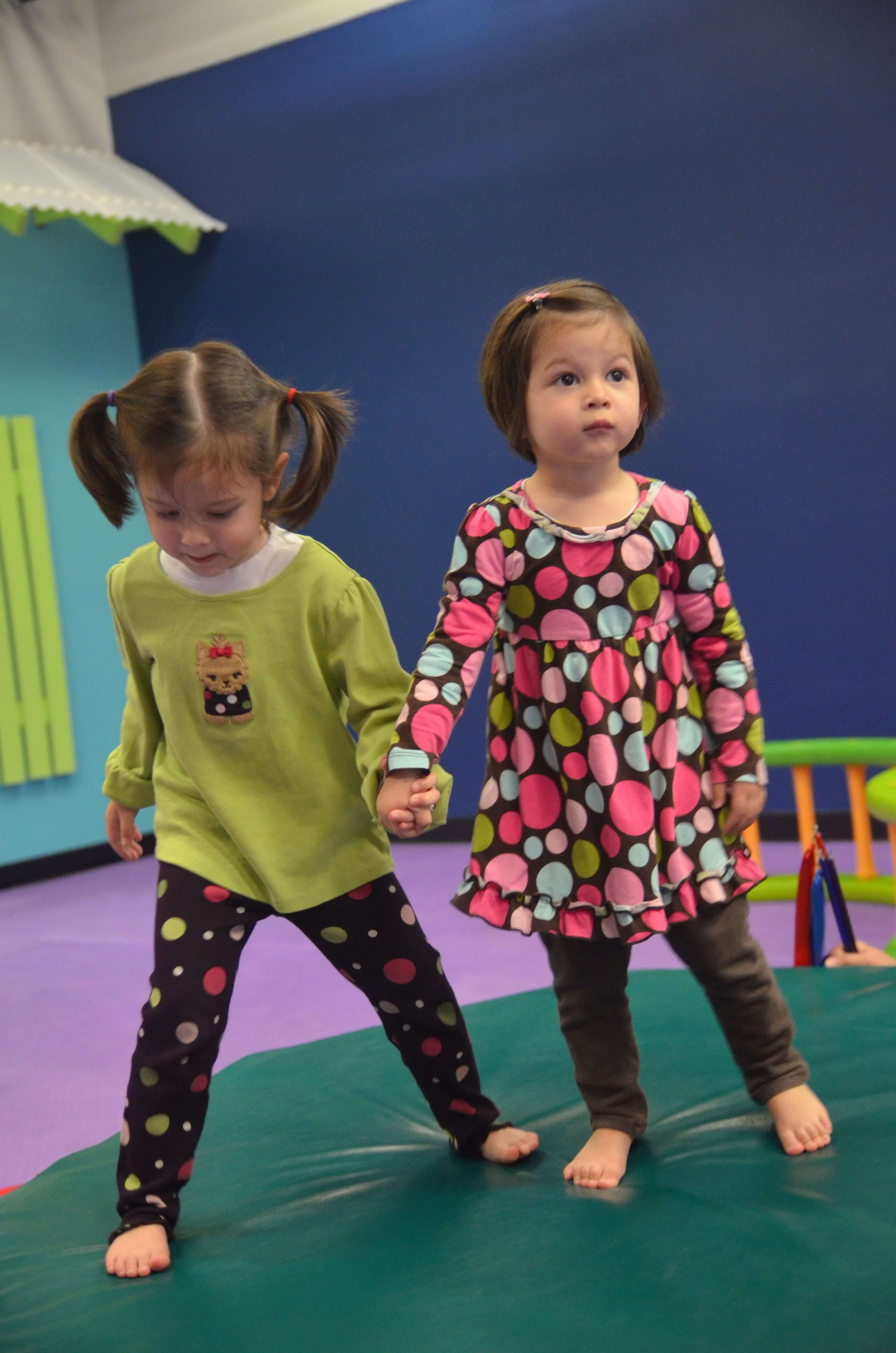 Two kids holding hands and playing indoors on a playdate - Romp n' Roll in Wethersfield