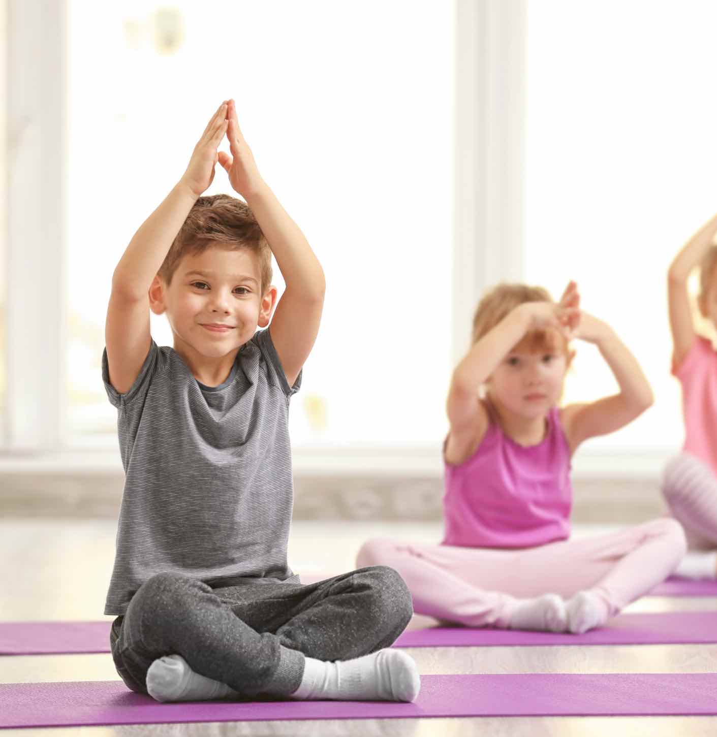 These kids enjoy practicing mindfulness through yoga - learn more tips with Romp n' Roll North Raleigh!