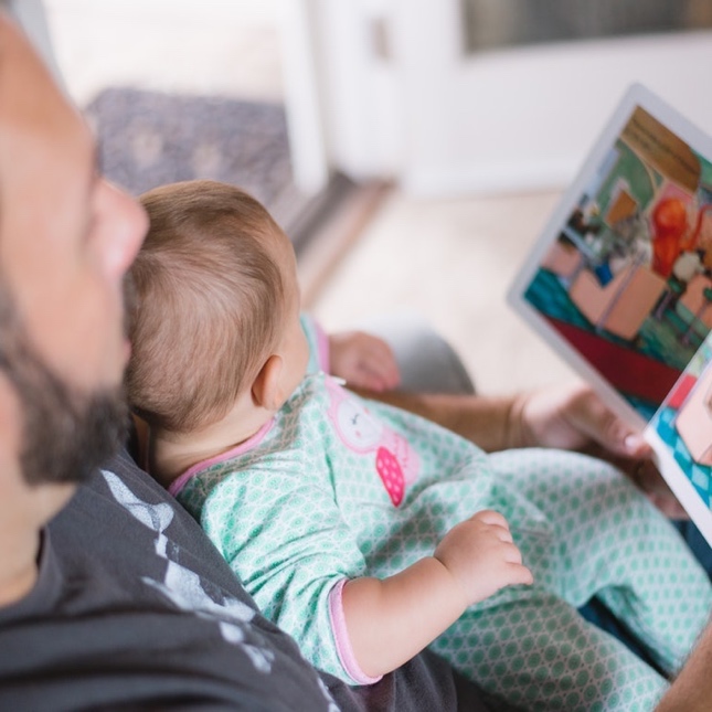 Dad and daughter reading a book together - learn more about summer learning tips with Romp n' Roll Katy.