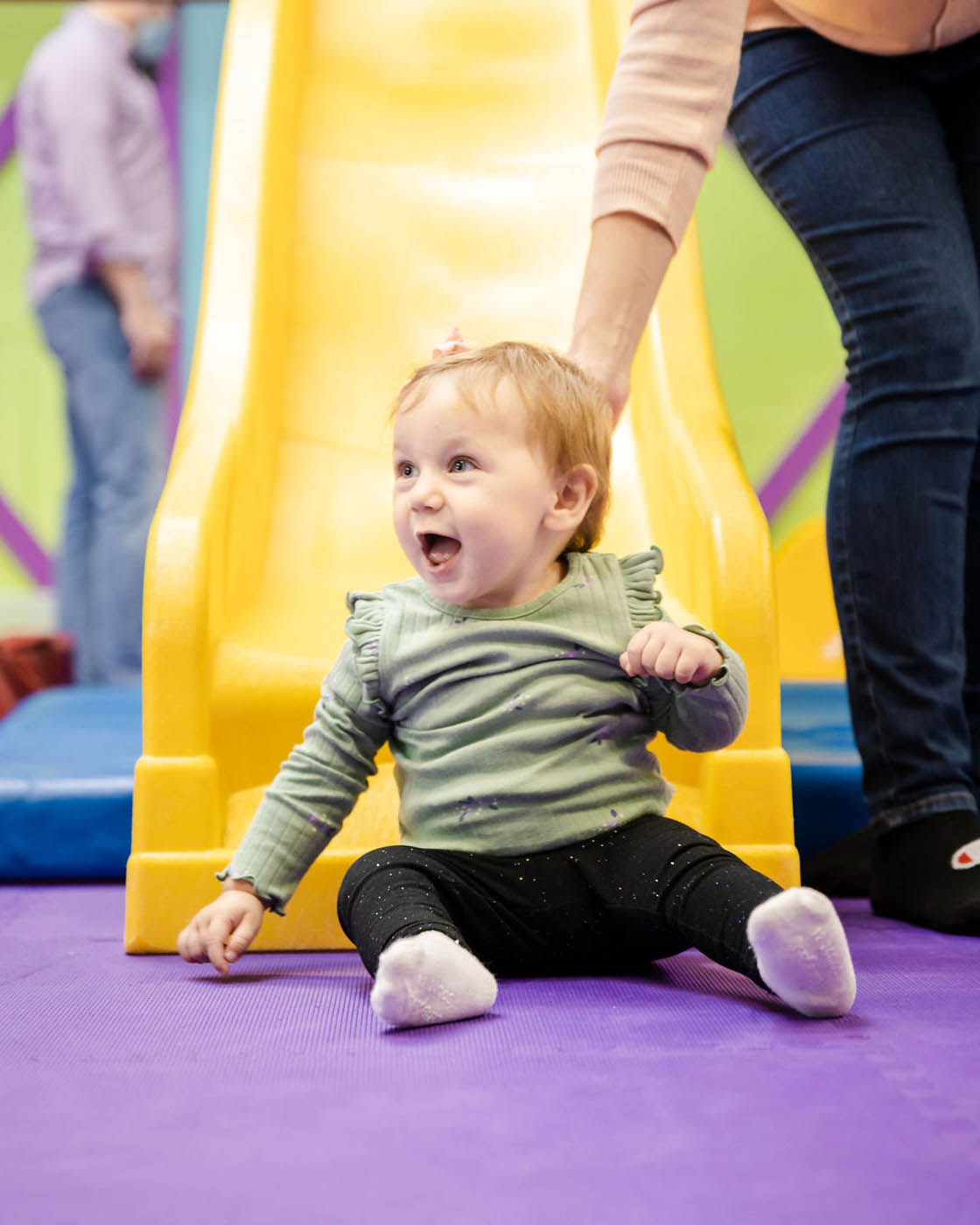 A very excited boy who just slid down a slide at Romp n' Roll.