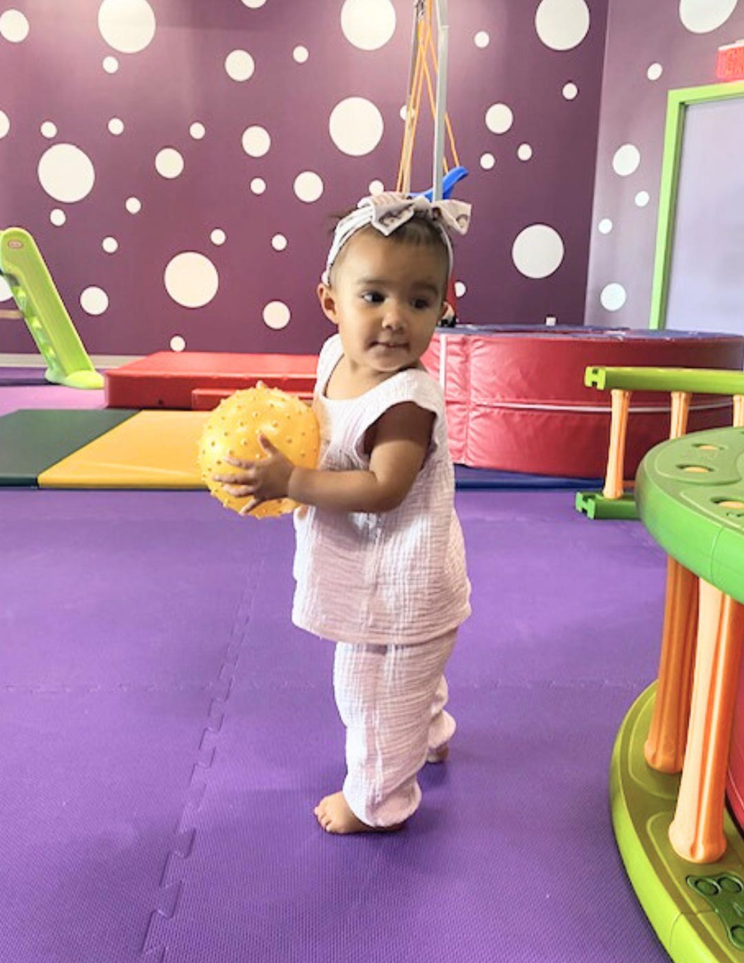 A little girl playing at Romp n' Roll kids gym. 