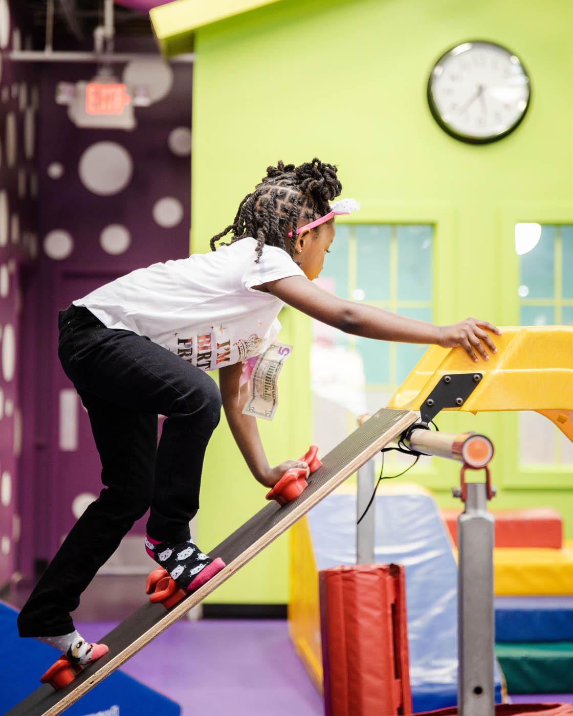 An older girl climbing on gym equipment at Romp n' Roll.
