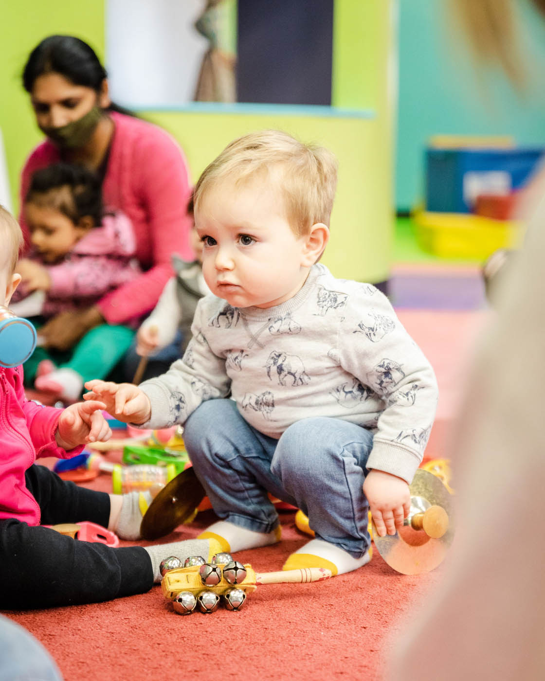 A boy playing with age-appropriate toys and other children at Romp n' Roll's indoor playground franchise.