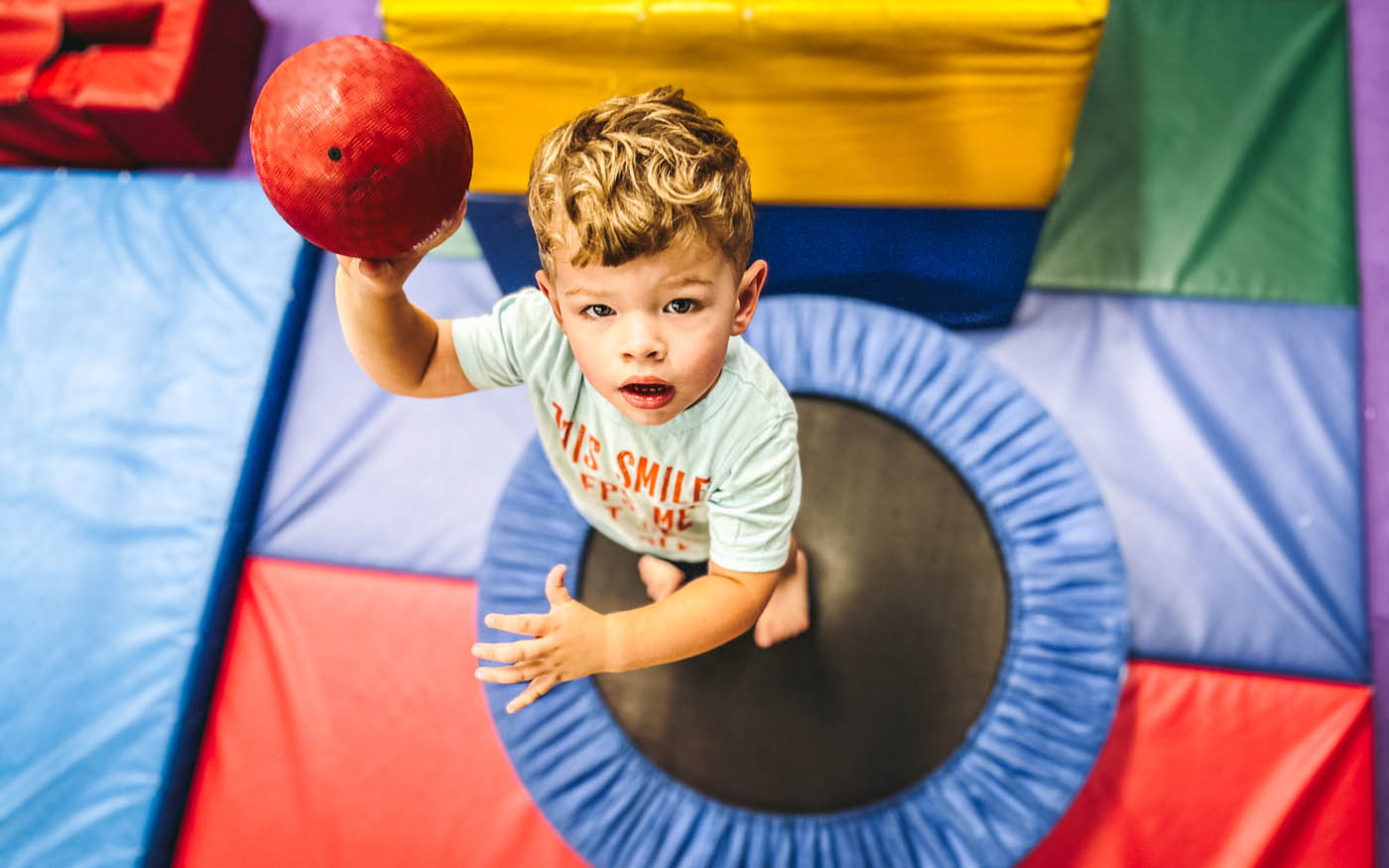 A young toddler playing on Romp n' Roll's gym on a tramp.