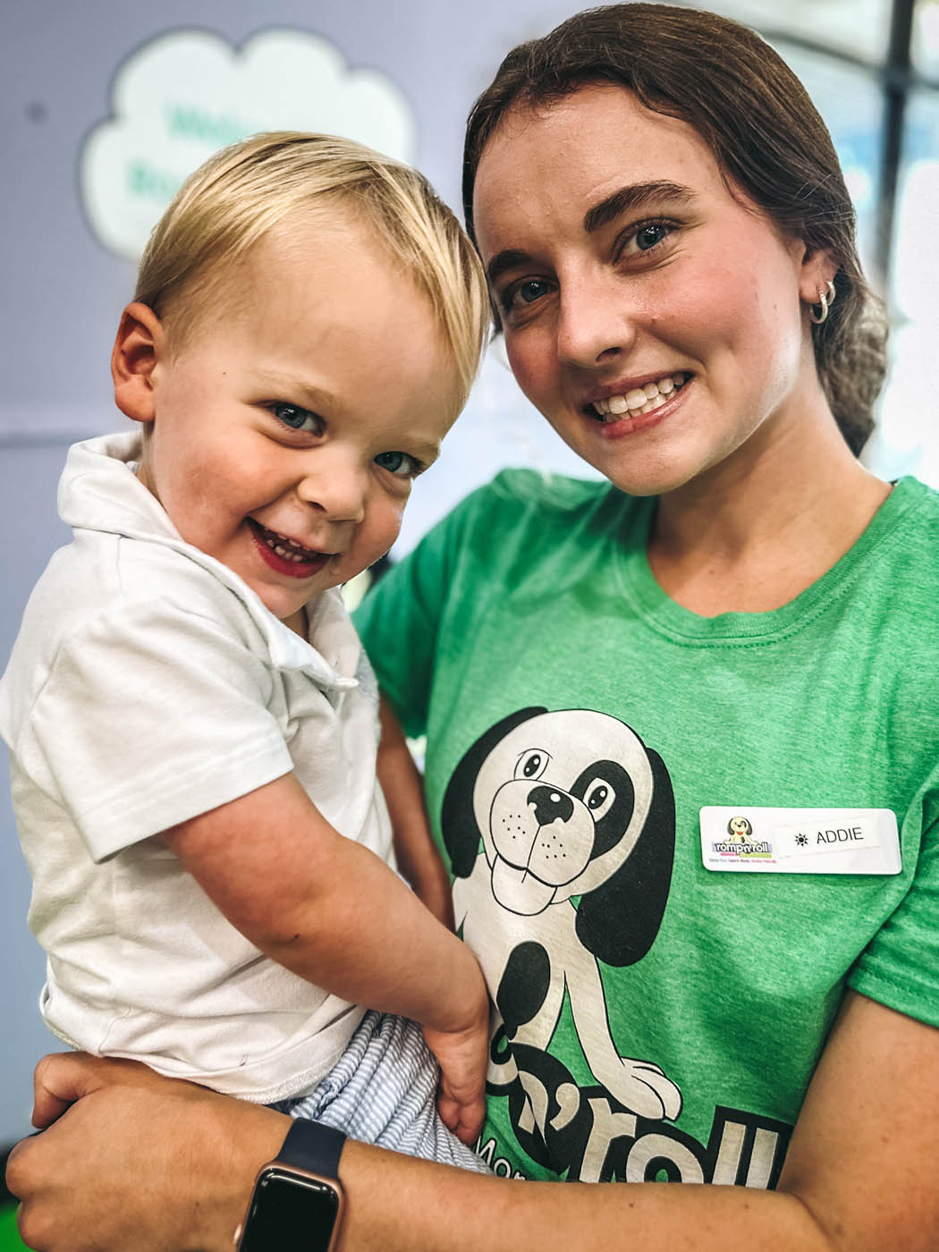 A baby boy being held by one of Romp n' Roll's staff members.