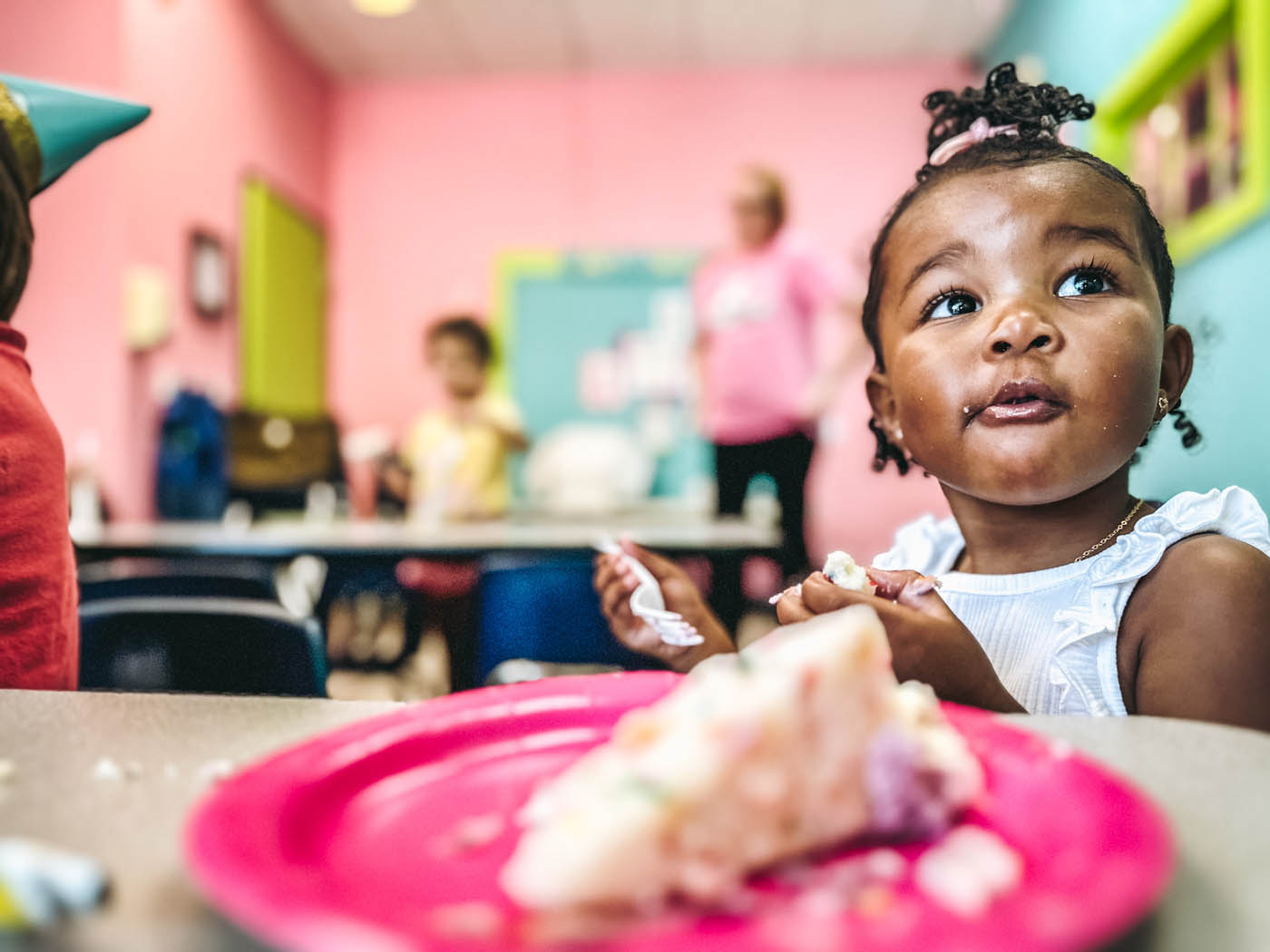 A little toddler enjoying some cake at Romp n' Roll birthday parites.